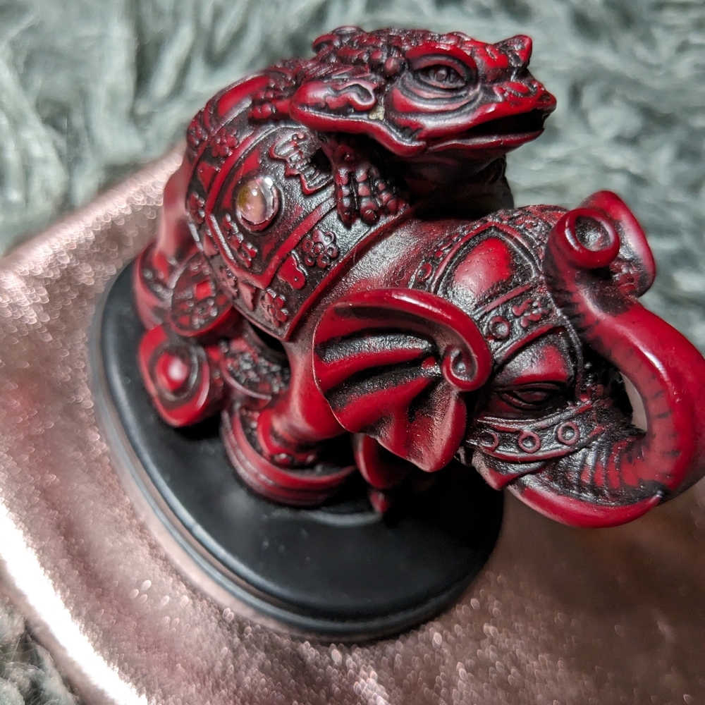 Wealth token frog on top of elephant